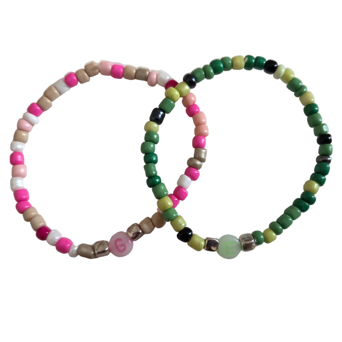 Wicked-inspired bracelet duo with a pink, white, and cream Glinda design and a green, pale yellow, and black Elphaba design with metallic accents